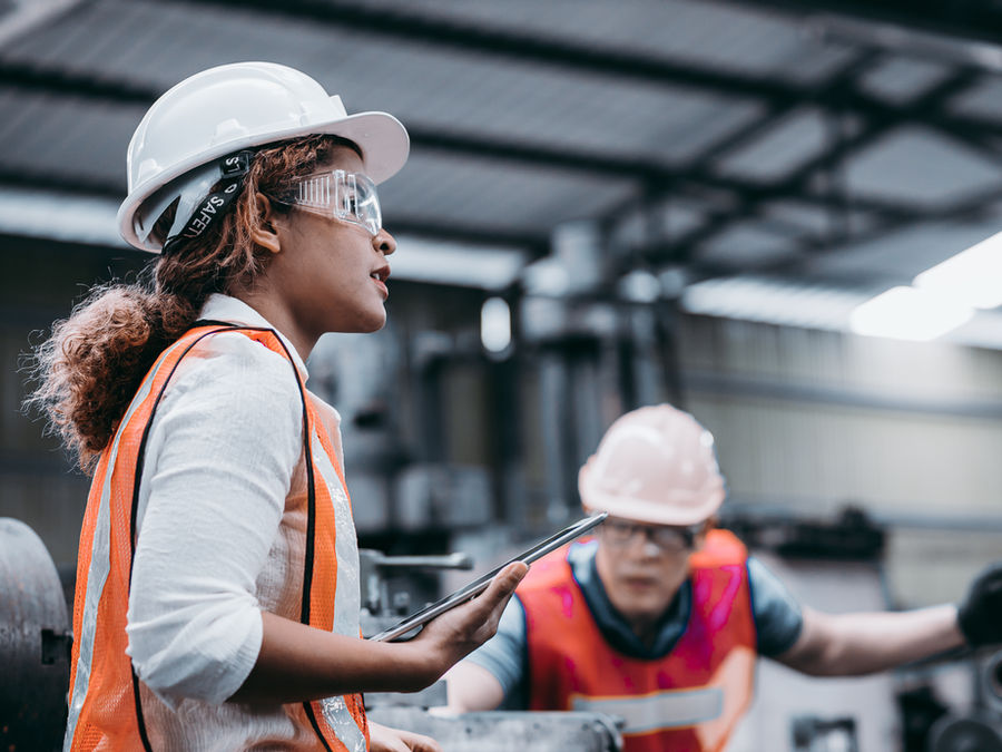 Manufacturing leaders reviewing work on a factory floor